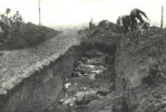 Dode soldaten worden na afloop van de slag begraven in een massagraf - klik hier voor vergroting